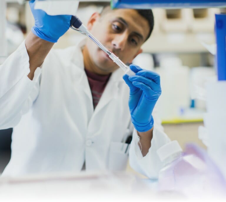 Scientist pipetting liquid into a tube